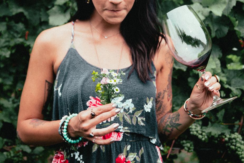 womens-fashion-tattooed-woman-holding-flowers-and-wine.jpg